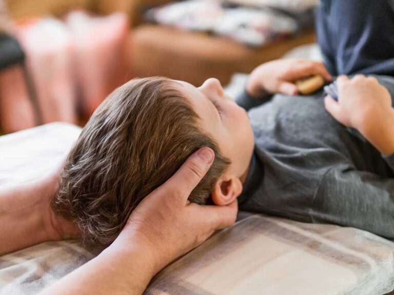 A chiropractor and physical therapist discussing a patient's spine X-ray and treatment plan together in an office.